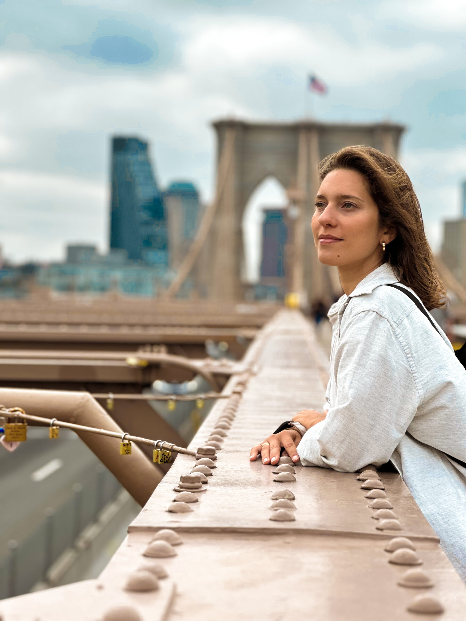 Nuny pelo Mundo - Foto da Hayuni olhando para um visual de viagem, centro urbano com um ponte ao fundo.